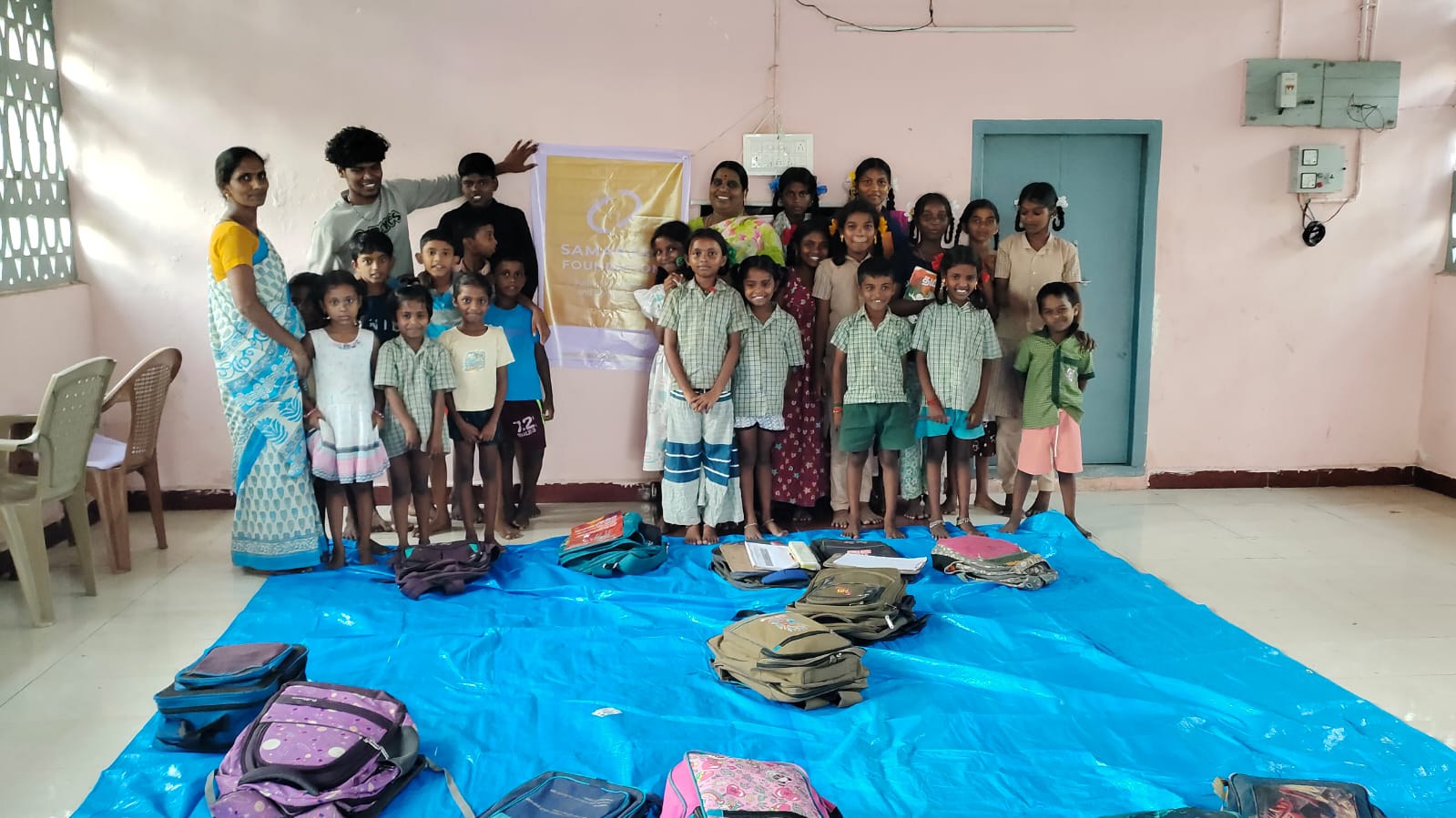 Children, teachers, and the Samarasa Foundation banner in a community classroom.